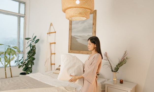Woman with a Comfortable Pillow as a Part of Better Bedroom Sleep Habits