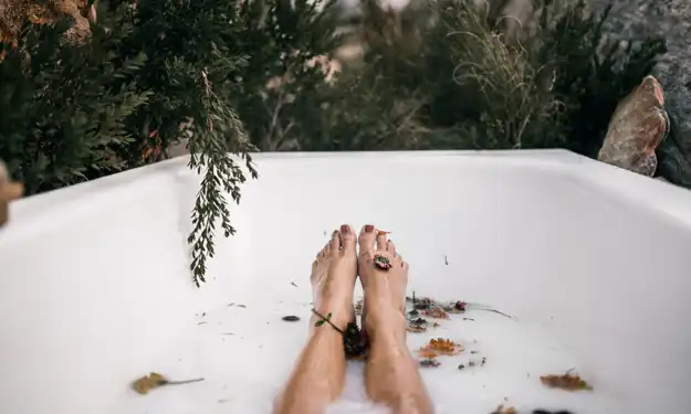 Woman Soaking in Outdoor Bathtub Soothing Sore Cracked Heels
