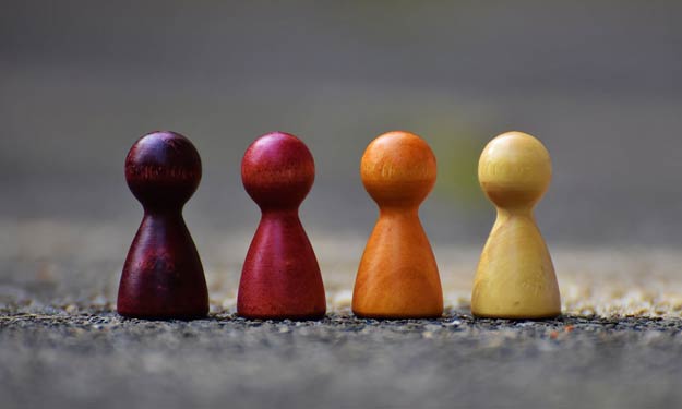 Wooden Pegs of Different Colors Representing Community.